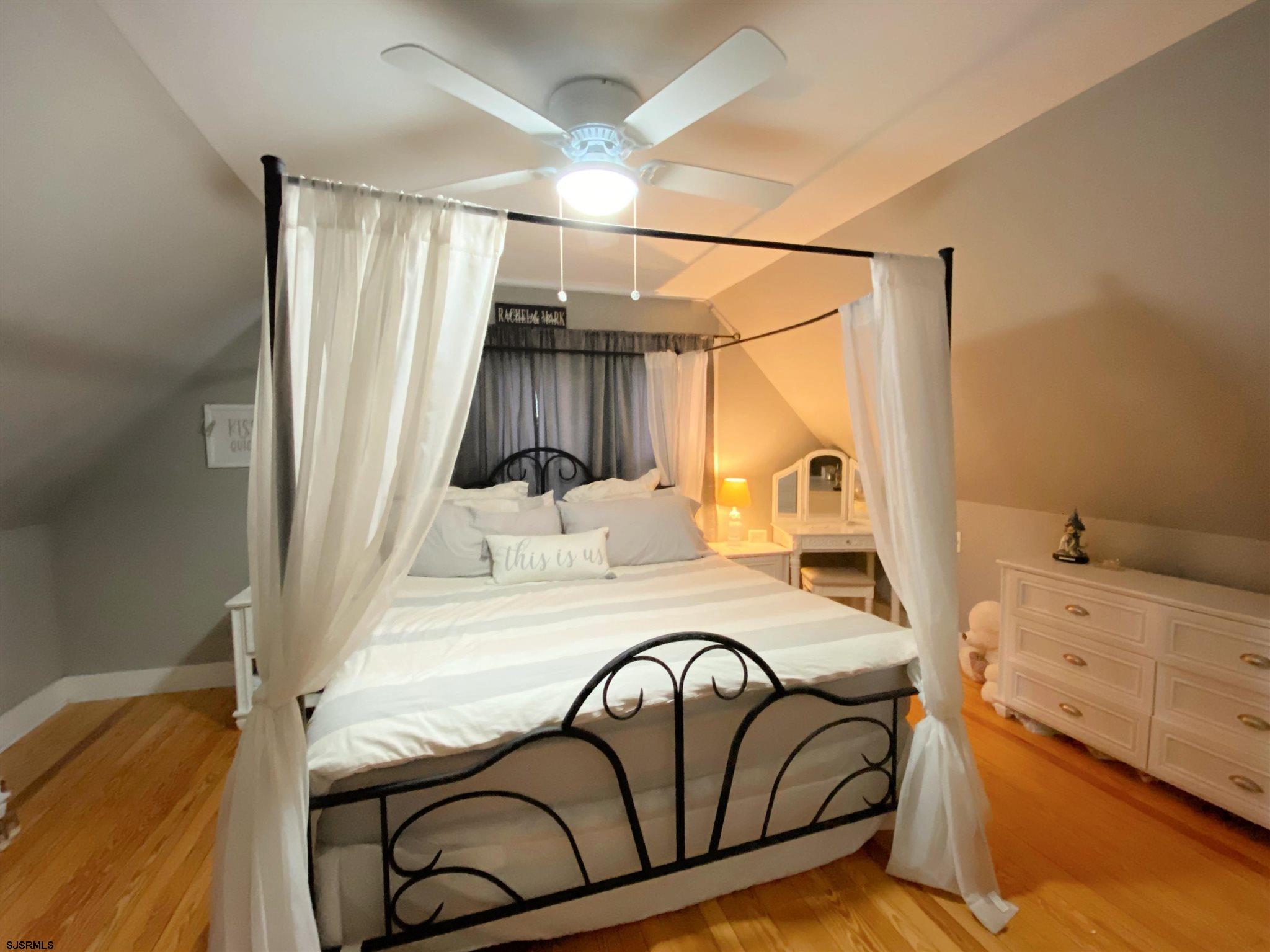 220 West Mill Road Northfield, NJ 08225 - Photo 11 of 22 a bedroom with a bed and a chandelier