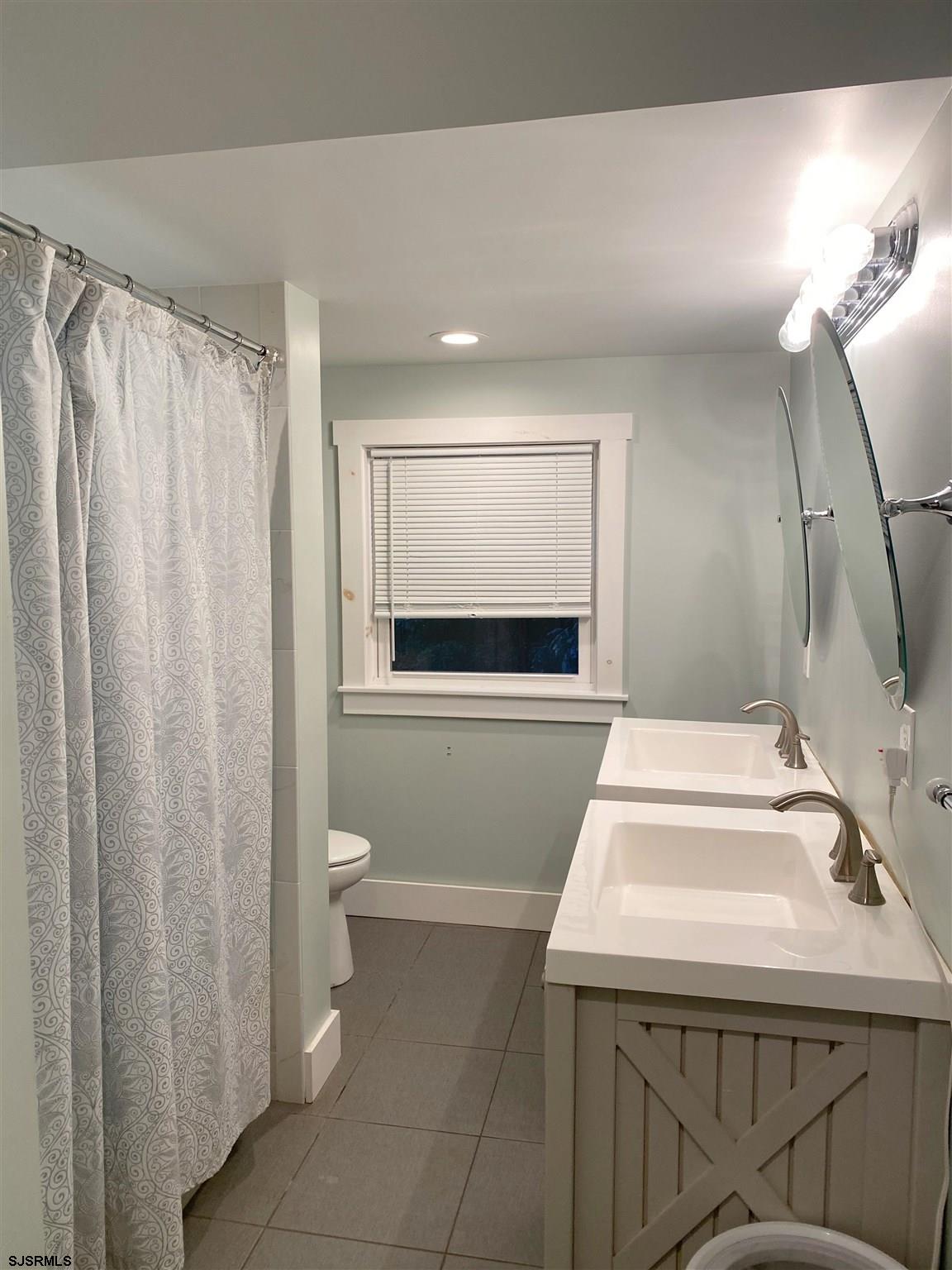 220 West Mill Road Northfield, NJ 08225 - Photo 14 of 22 a bathroom with a sink a toilet and shower