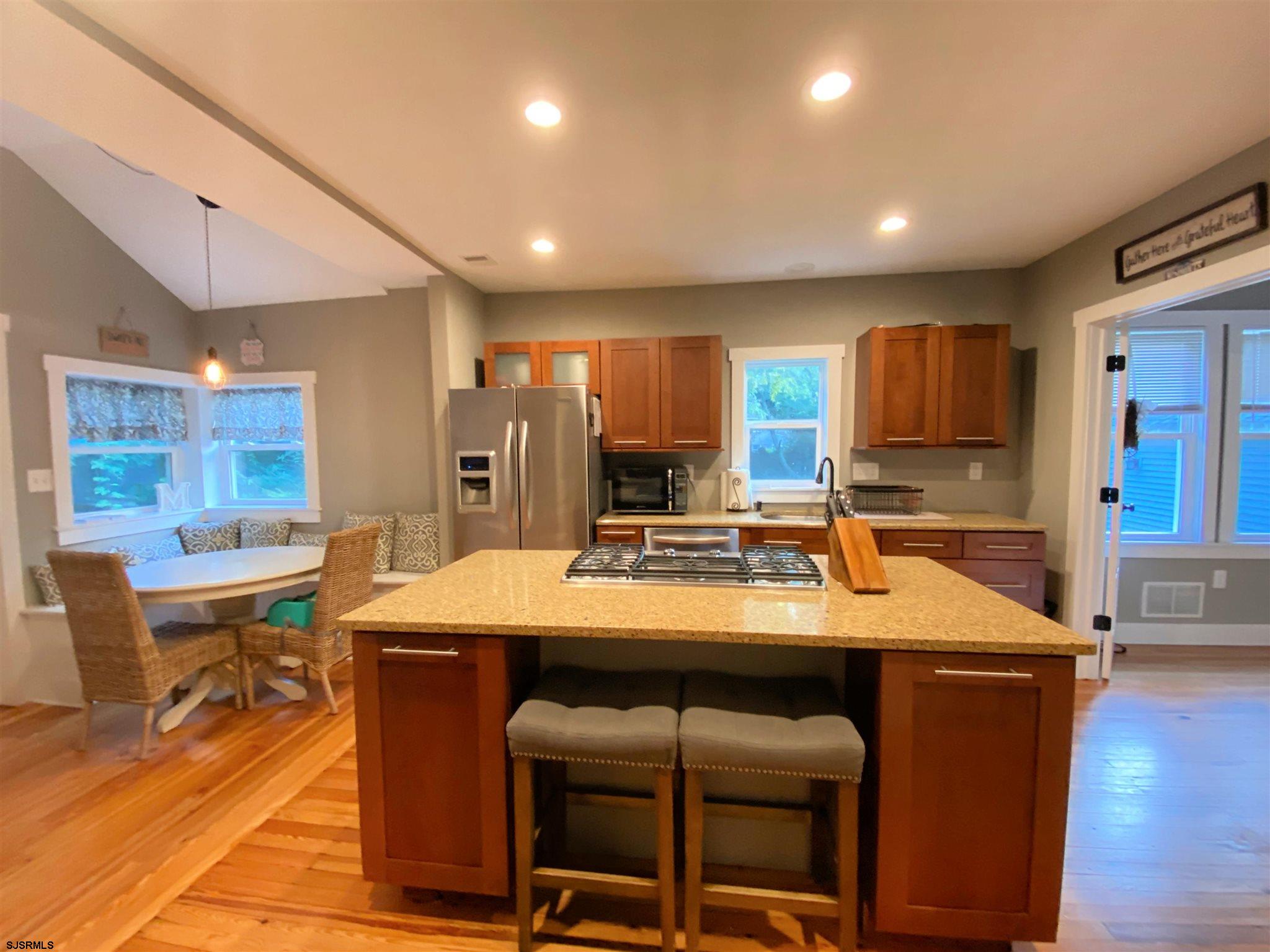 220 West Mill Road Northfield, NJ 08225 - Photo 4 of 22 a kitchen with a table chairs refrigerator and cabinets