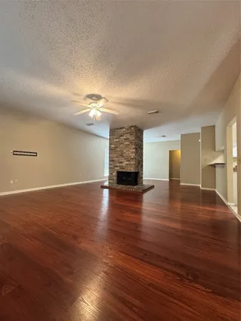 a view of empty room with wooden floor and window