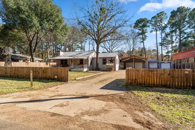 a view of a white house with a large tree in front of it