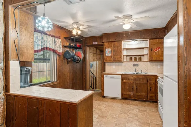 a kitchen that has a lot of cabinets and refrigerator in it