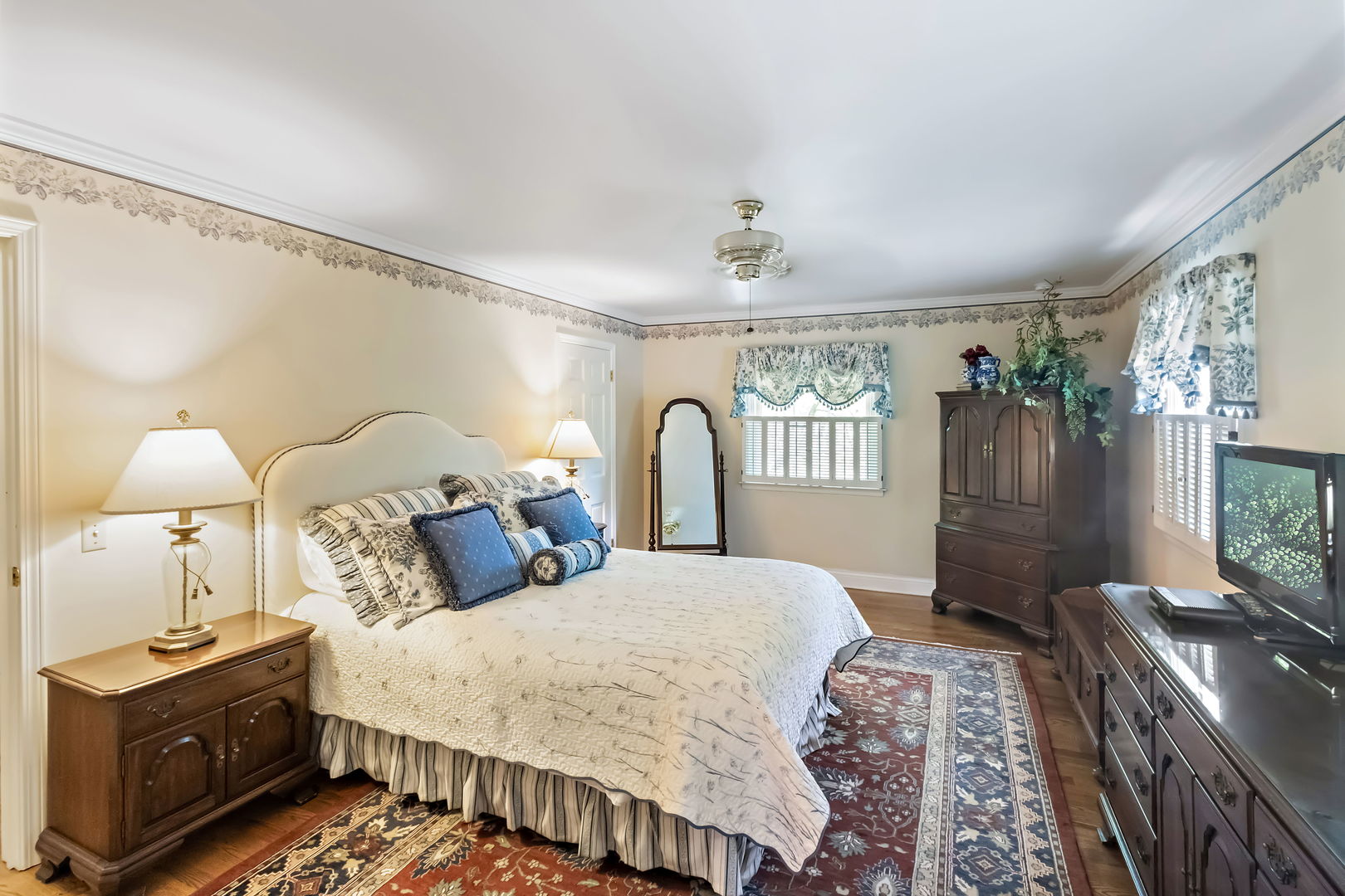 1219 Howard Circle Wheaton, IL 60187 - Photo 13 of 26 a bedroom with a bed and a flat tv screen on dresser