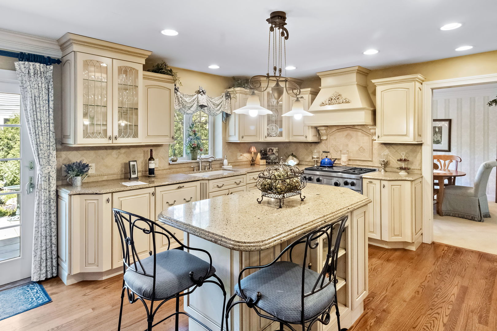 1219 Howard Circle Wheaton, IL 60187 - Photo 9 of 26 a kitchen with stainless steel appliances kitchen island a table chairs sink and wooden floor