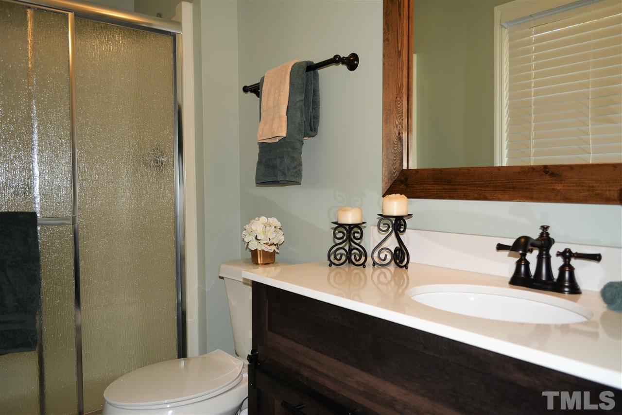 7249 Rock Service Station Road Raleigh, NC 27603 - Photo 15 of 25 New vanity, new mirror, new lighting, new flooring and paint, new toilet-wow!