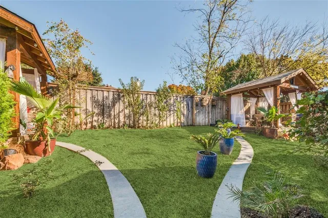 a view of a house with a yard and potted plants