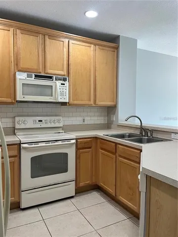 a kitchen with cabinets stainless steel appliances and a window