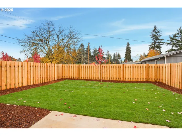 a view of a backyard with wooden fence
