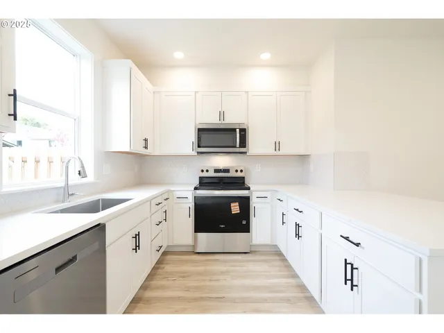 a kitchen with granite countertop a stove top oven sink and cabinets
