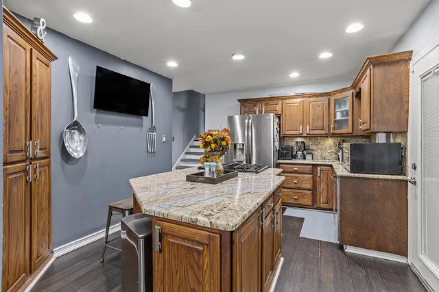 a kitchen with stainless steel appliances microwave stove refrigerator and wooden floor