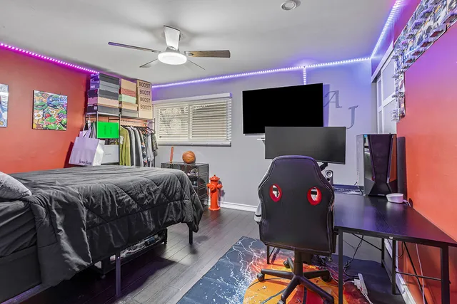 a bedroom with a bed a flat screen tv and a chandelier