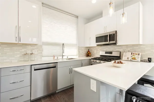 a kitchen with sink a microwave and cabinets