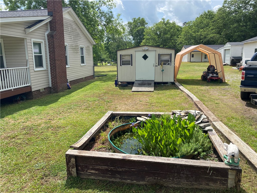 3 Heyward Avenue Honea Path, SC 29654 - Photo 25 of 35 This outdoor space offers practical storage solutions and a charming decorative pond.