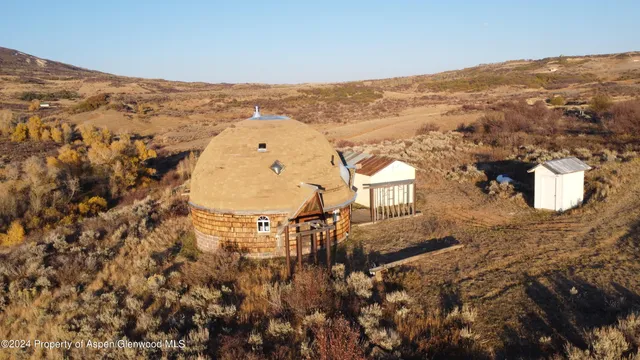 an aerial view of a house with a mountain