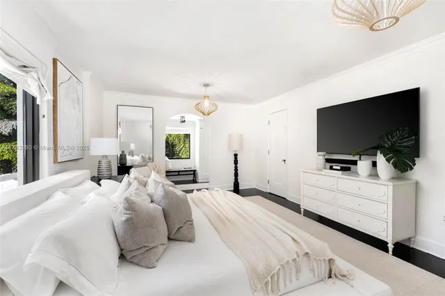 a bedroom with a bed and a flat screen tv