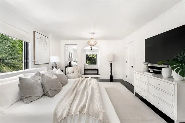 a spacious bedroom with a large bed and a flat screen tv