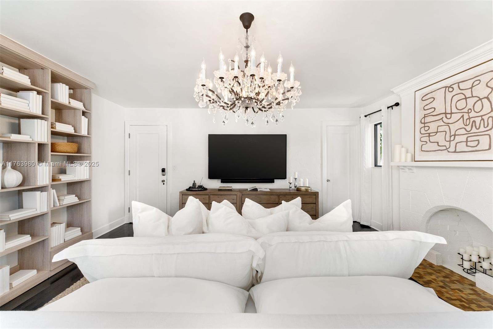 4430 Alton Road Miami Beach, FL 33140 - Photo 25 of 47 a living room with furniture a chandelier and a flat screen tv