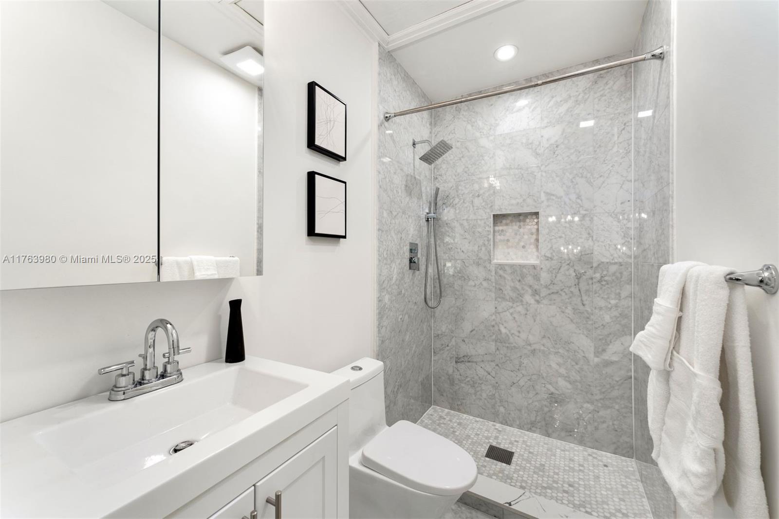 4430 Alton Road Miami Beach, FL 33140 - Photo 26 of 47 a bathroom with a sink a toilet and shower