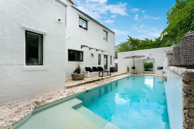 a view of a house with swimming pool and sitting area