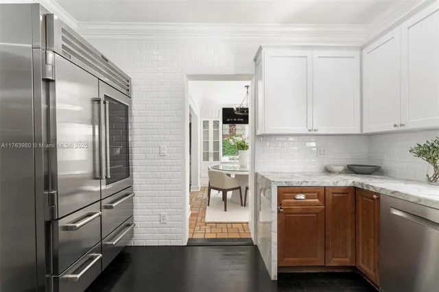 a kitchen with a refrigerator and white cabinets