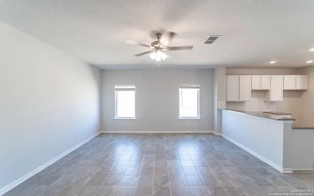 a view of an empty room with window and cabinet