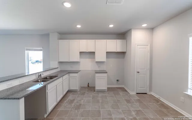 a large kitchen with stainless steel appliances granite countertop a sink and cabinets