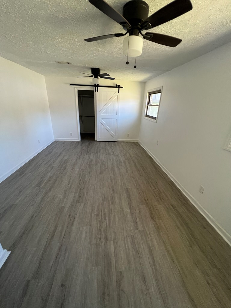 5220 Teresa Street Columbus, GA 31907 - Photo 15 of 21 an empty room with wooden floor windows and fireplace