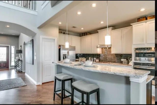 a kitchen with stainless steel appliances granite countertop a sink a stove and a refrigerator