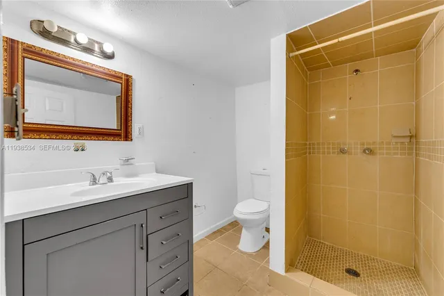 a bathroom with a granite countertop sink mirror toilet and shower