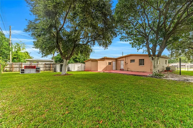 a view of a house with a big yard and large tree