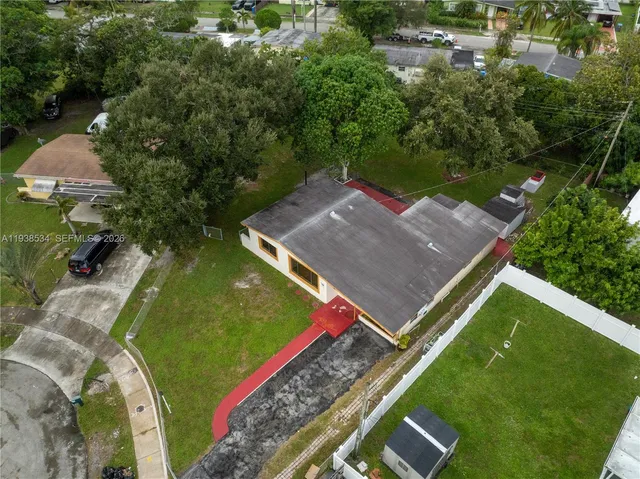 an aerial view of a city with lots of residential buildings ocean and mountain view in back