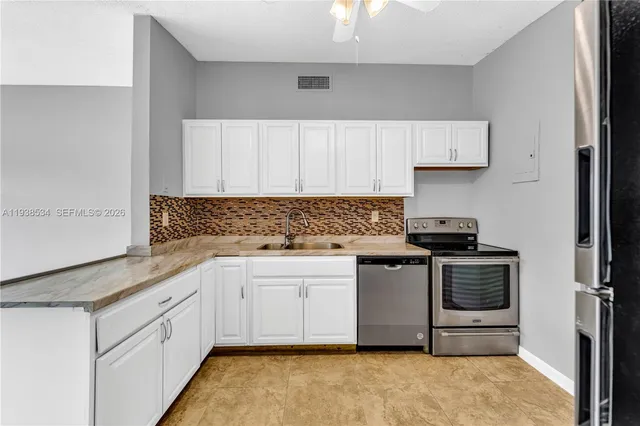 a kitchen with stainless steel appliances granite countertop a stove a sink and a refrigerator