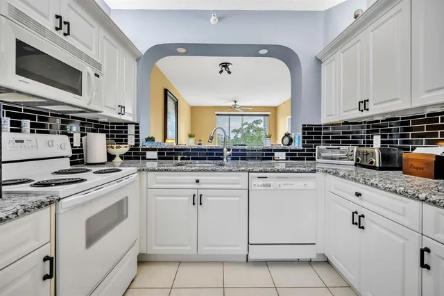 a kitchen with white cabinets appliances and a sink