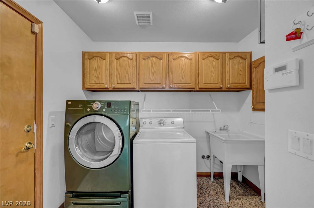 640 North Racetrack Road Henderson, NV 89015 - Photo 25 of 65 Functional laundry room equipped with upper cabinetry and a utility sink, ready for household tasks.