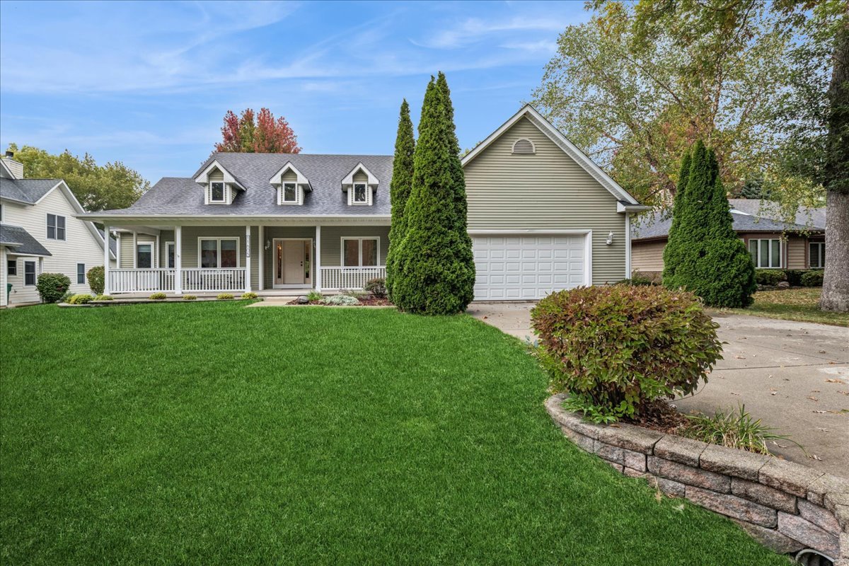 a front view of a house with a yard and potted plants