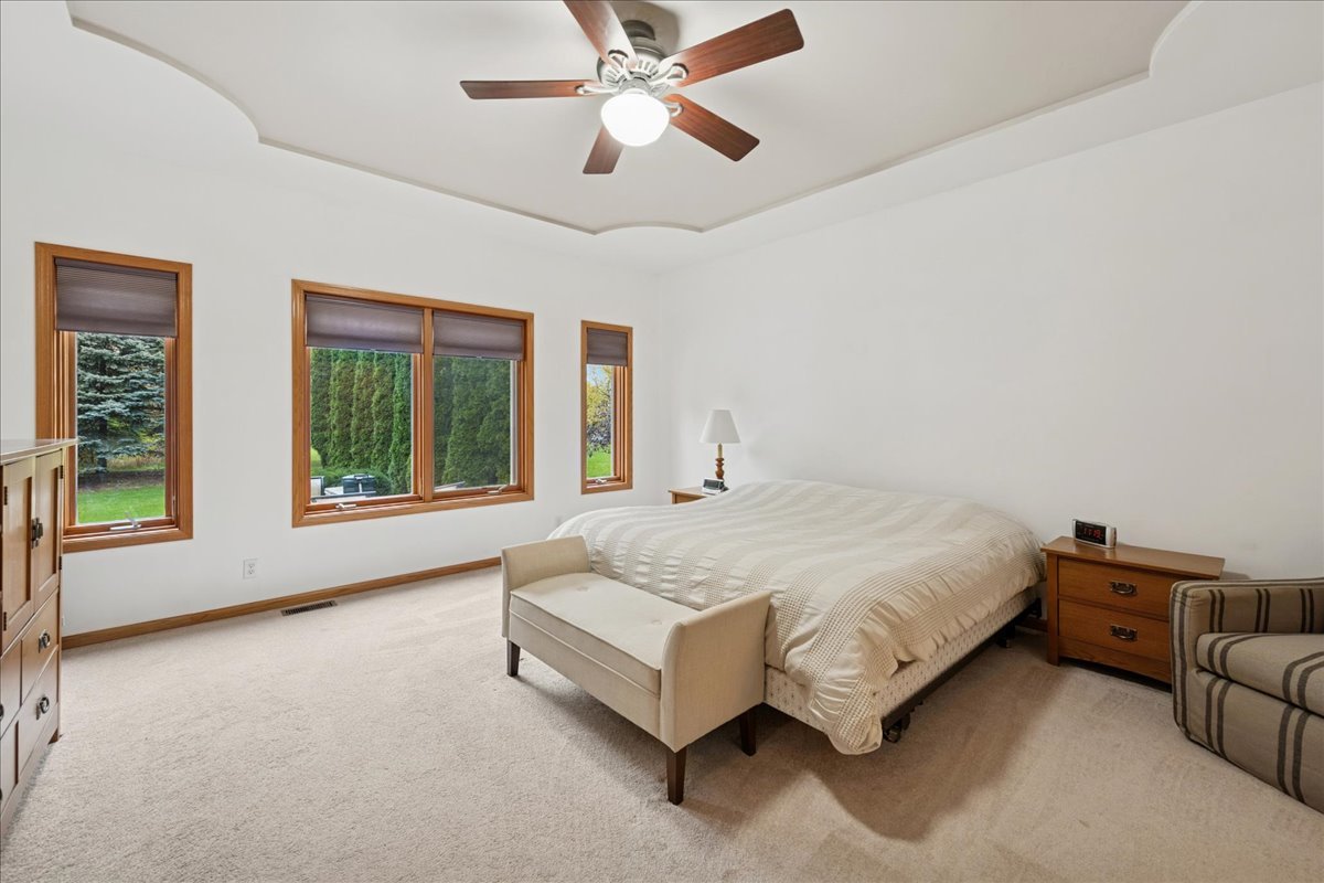 11605 Ellwood Greens Road Genoa, IL 60135 - Photo 11 of 25 a spacious bedroom with a bed couch and window