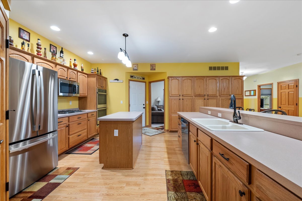 11605 Ellwood Greens Road Genoa, IL 60135 - Photo 6 of 25 a kitchen with stainless steel appliances granite countertop a sink and a refrigerator