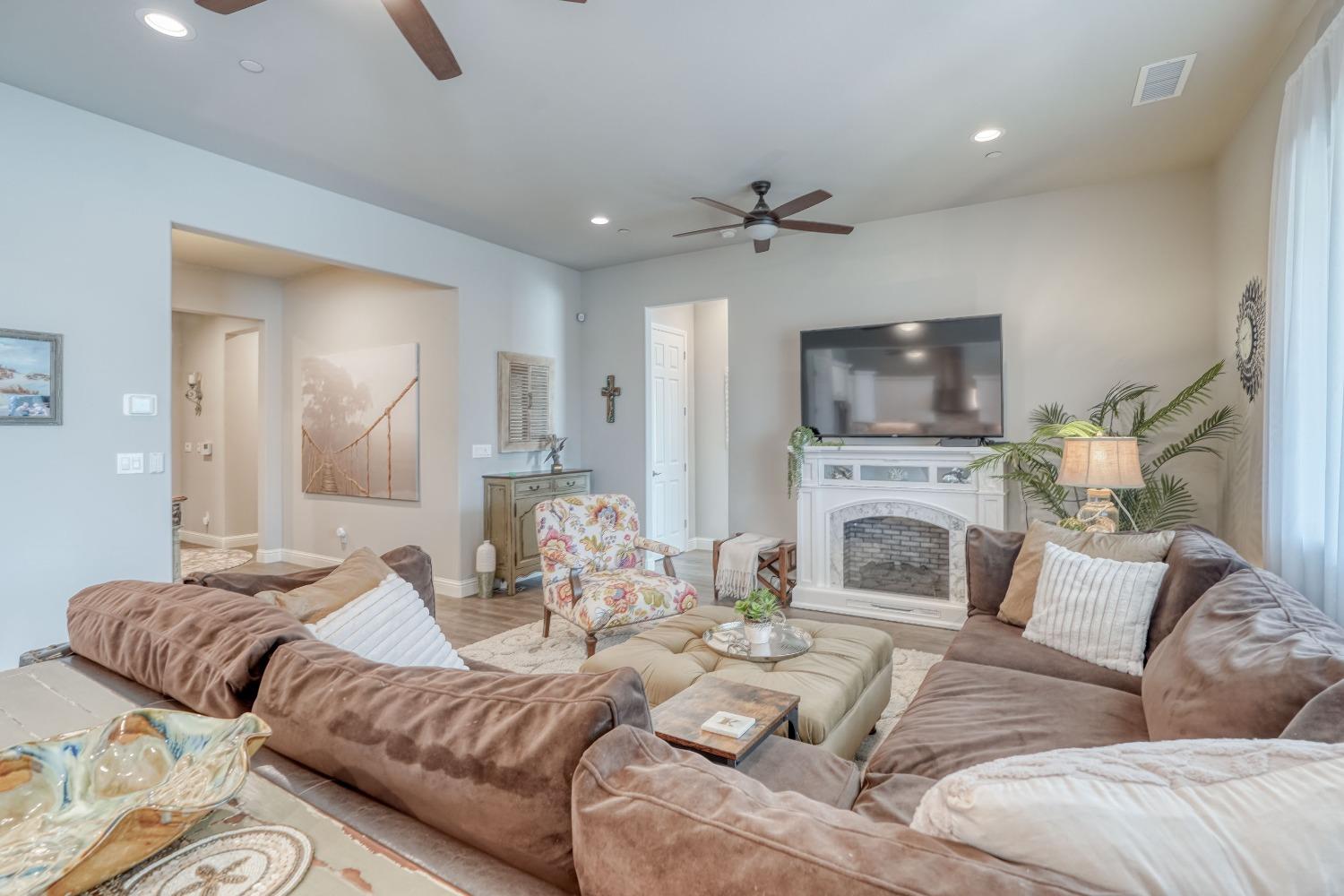 3048 Poe Avenue Clovis, CA 93619 - Photo 11 of 56 a living room with furniture a fireplace and a flat screen tv