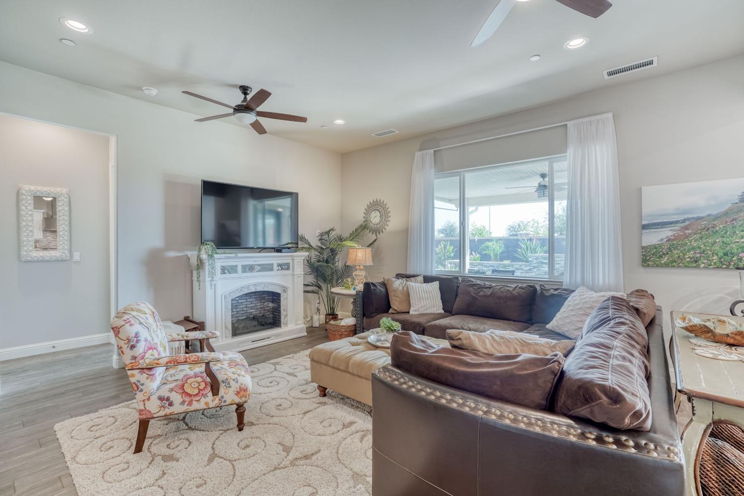 3048 Poe Avenue Clovis, CA 93619 - Photo 13 of 56 a living room with furniture a fireplace and a flat screen tv
