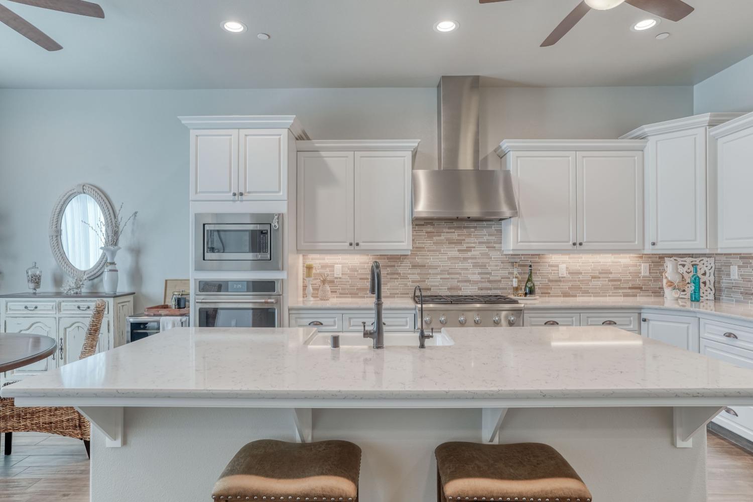 3048 Poe Avenue Clovis, CA 93619 - Photo 15 of 56 a kitchen with stainless steel appliances granite countertop a sink a stove and a microwave