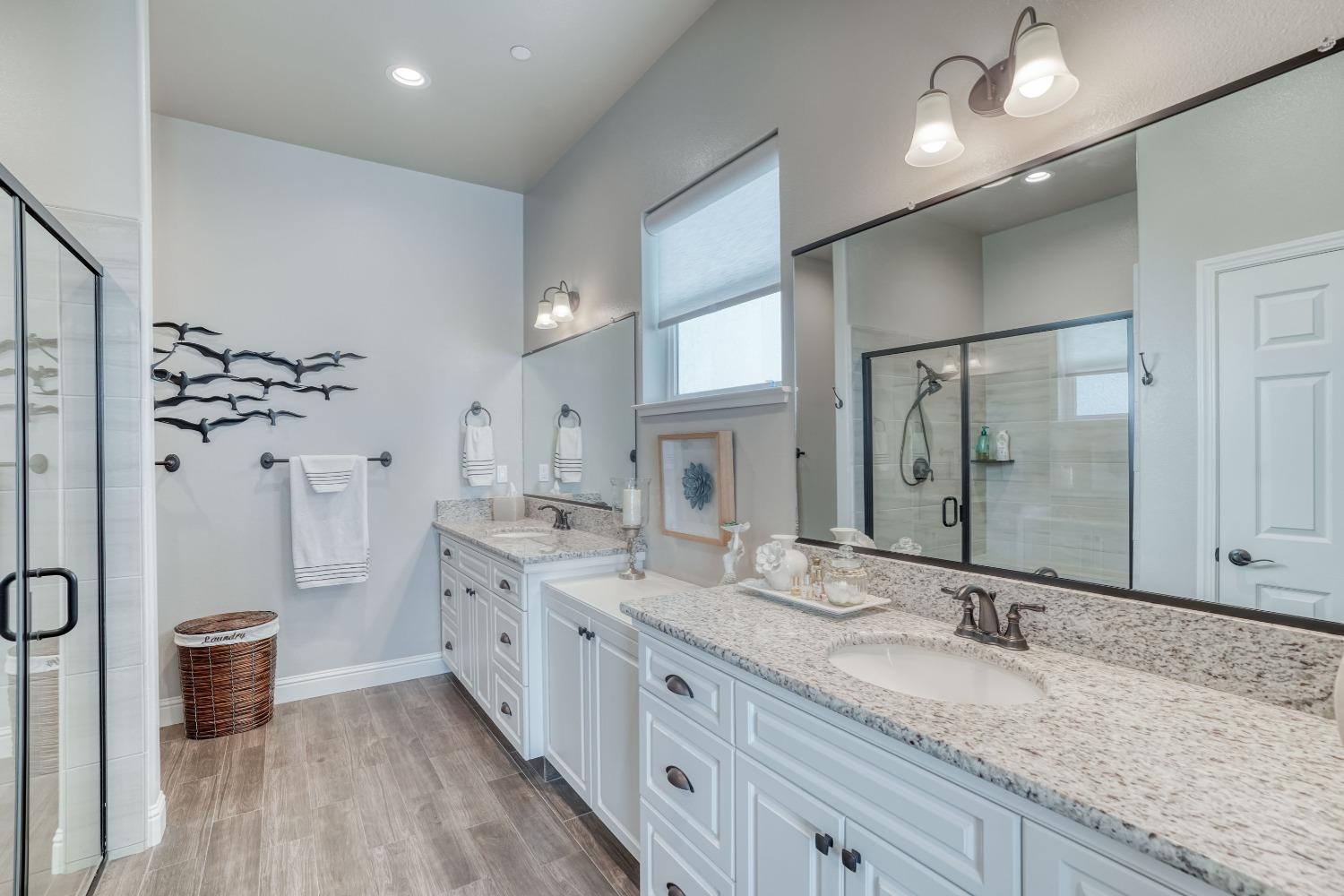3048 Poe Avenue Clovis, CA 93619 - Photo 25 of 56 a spacious bathroom with a granite countertop double vanity sink a mirror and a shower