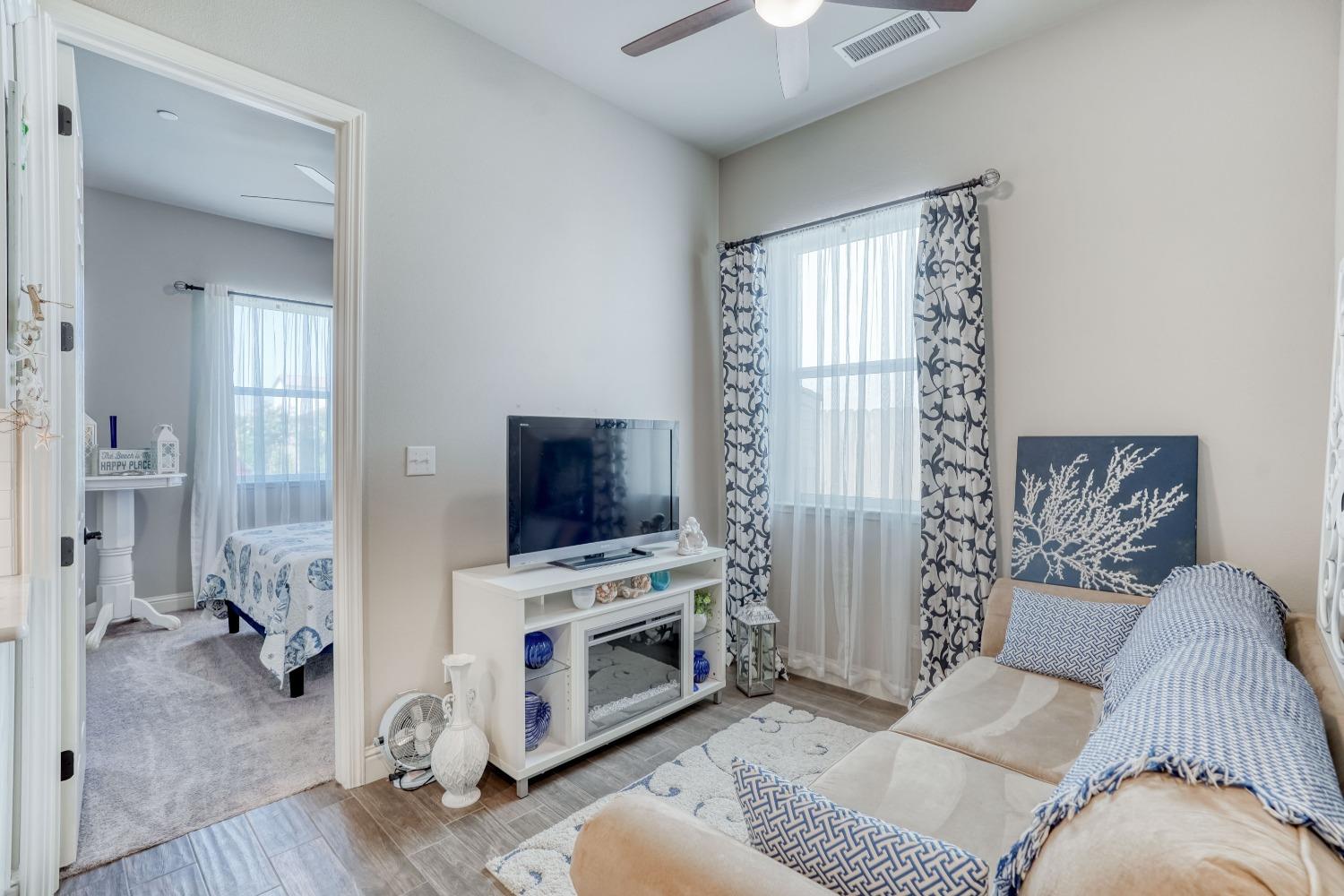 3048 Poe Avenue Clovis, CA 93619 - Photo 31 of 56 a living room with furniture a flat screen tv and a fireplace