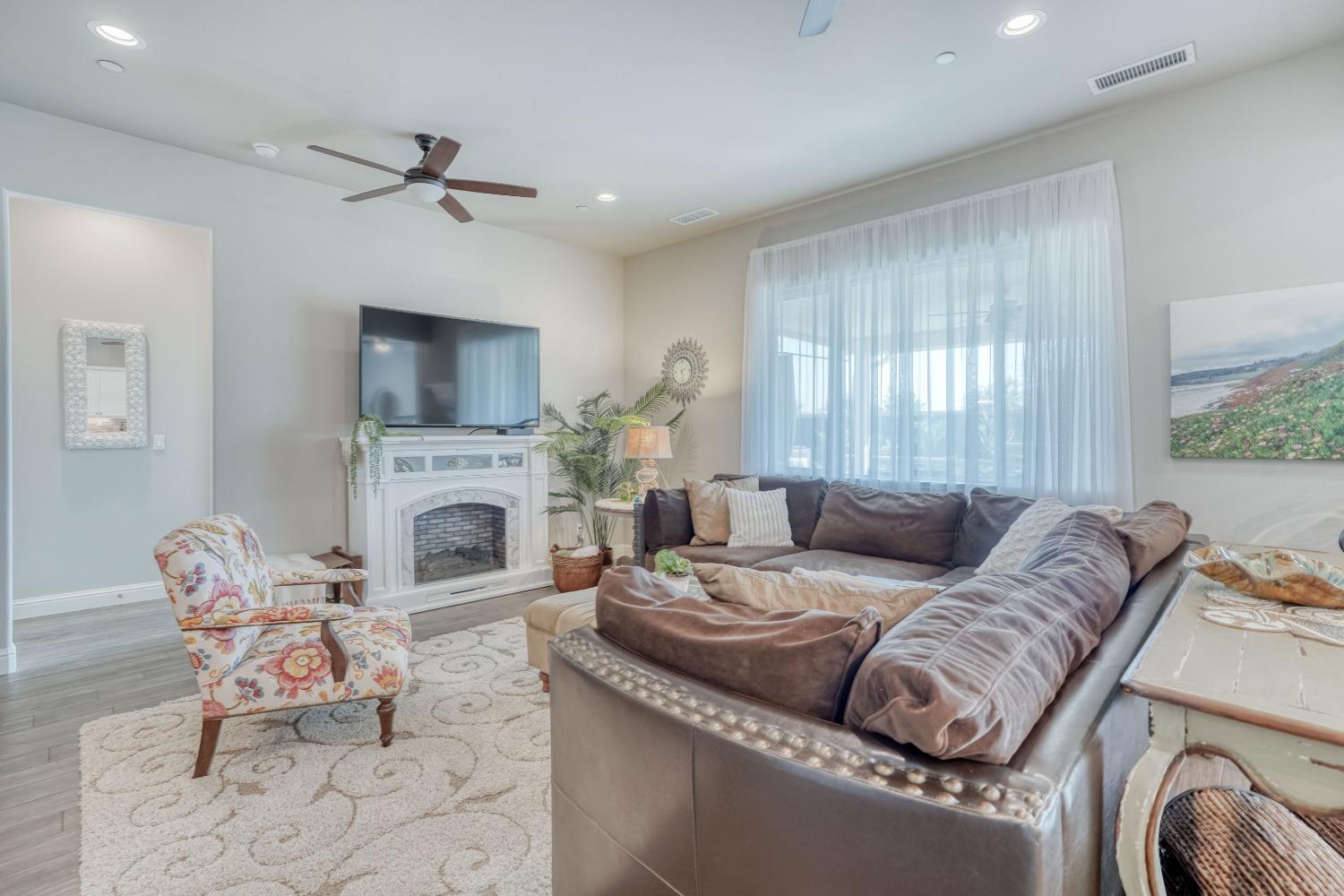 3048 Poe Avenue Clovis, CA 93619 - Photo 9 of 56 a living room with furniture a fireplace and a flat screen tv