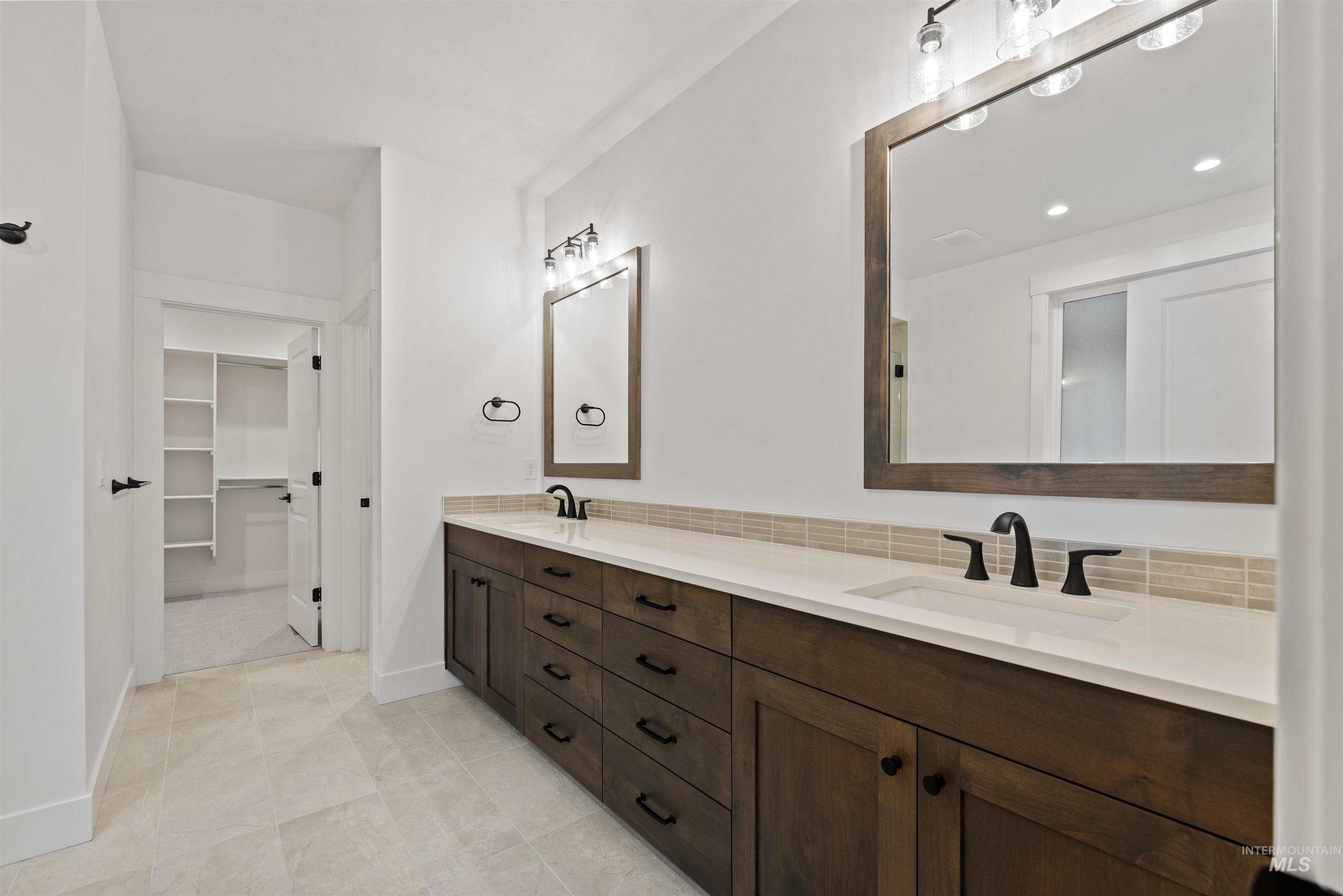 2129 East Blakehurst Street Kuna, ID 83634 - Photo 15 of 34 Full bath featuring double vanity, a walk in closet, and light tile patterned floors