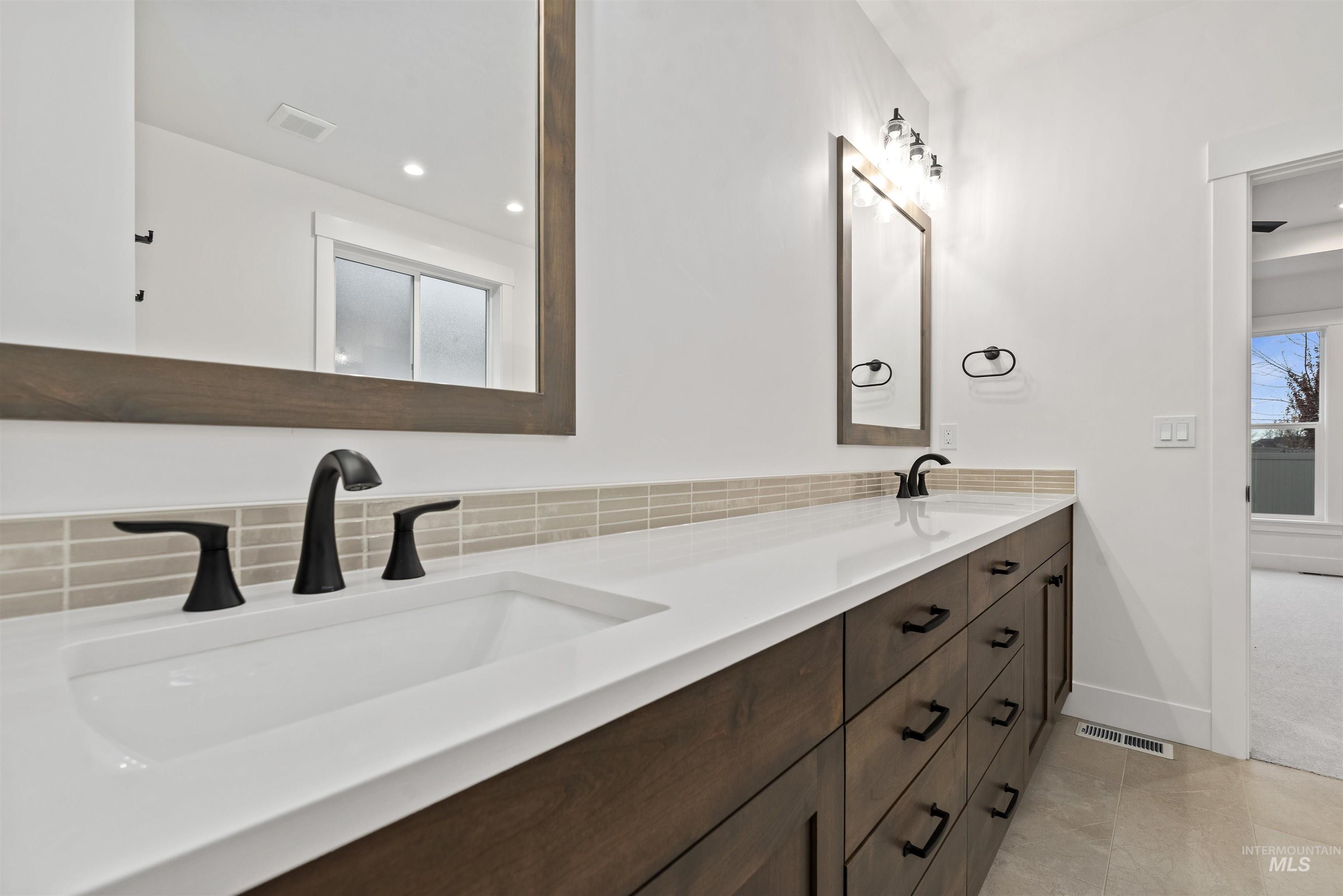 2129 East Blakehurst Street Kuna, ID 83634 - Photo 18 of 34 Bathroom with double vanity, recessed lighting, light tile patterned floors, and backsplash