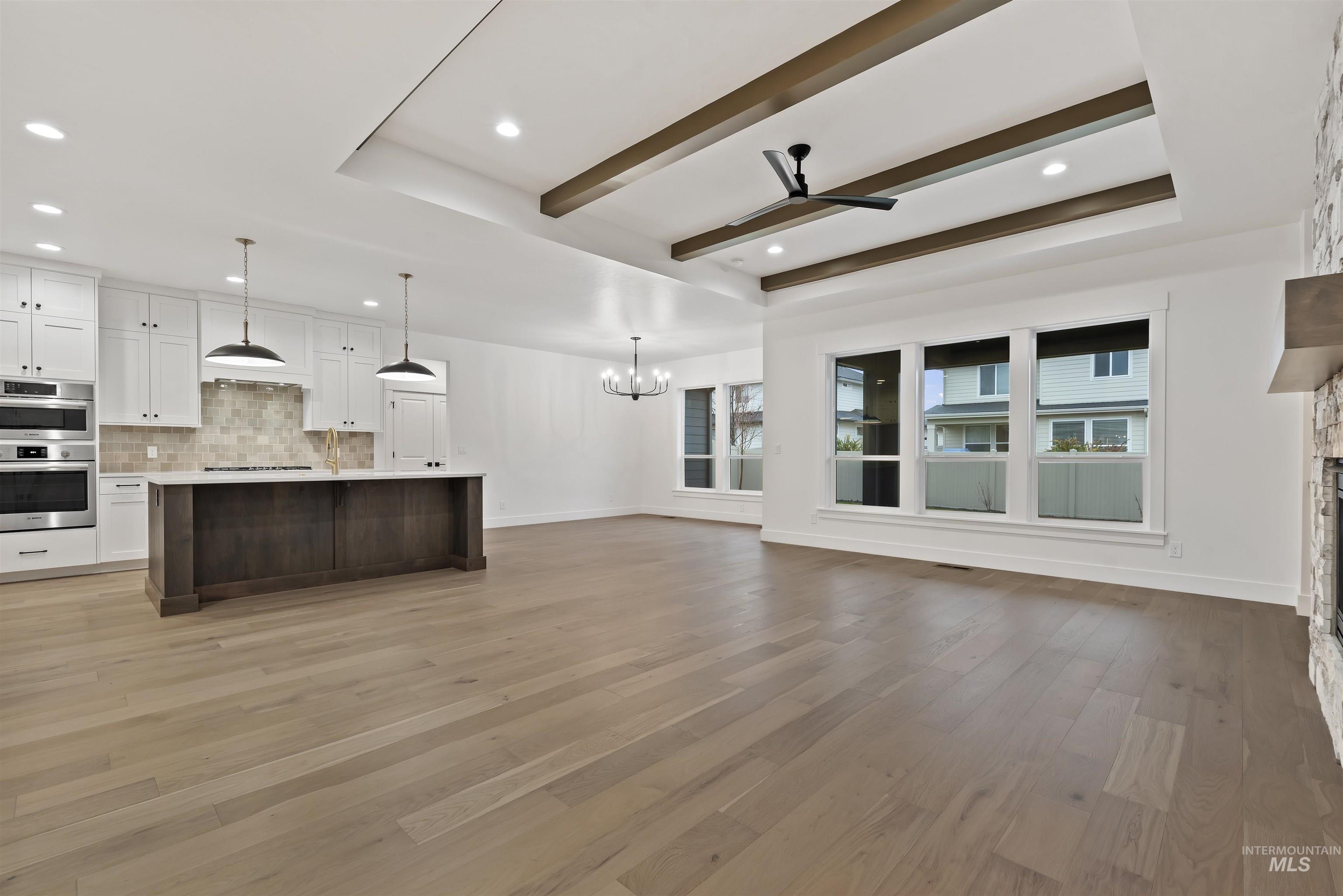 2129 East Blakehurst Street Kuna, ID 83634 - Photo 3 of 34 Unfurnished living room featuring a ceiling fan, light wood-style floors, a chandelier, a fireplace, and recessed lighting