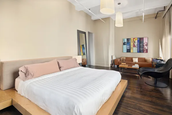 a bedroom with a bed and wooden floor