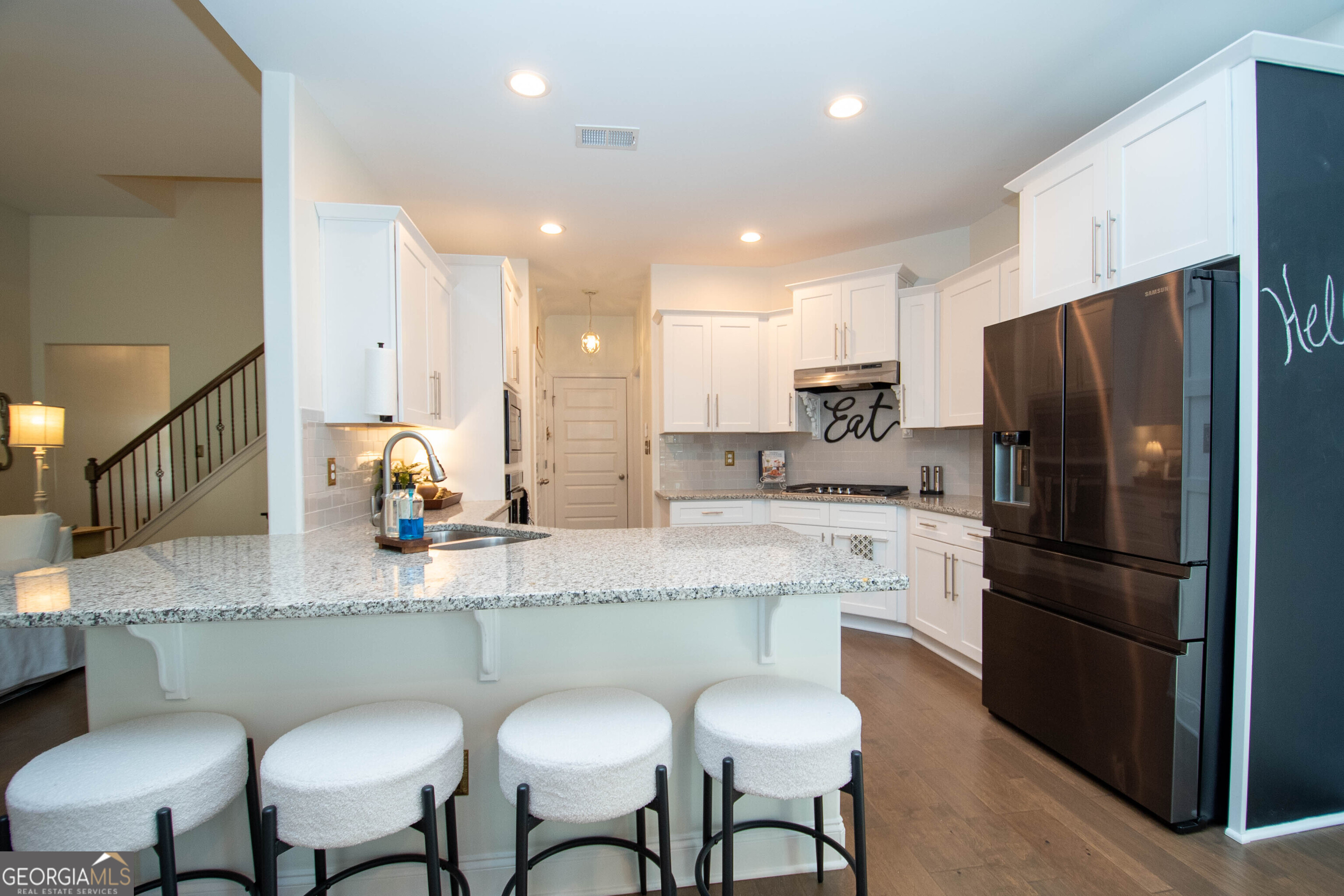 6 Delaware Way Newnan, GA 30265 - Photo 16 of 42 a kitchen with stainless steel appliances granite countertop a refrigerator a sink a stove a dining table and chairs