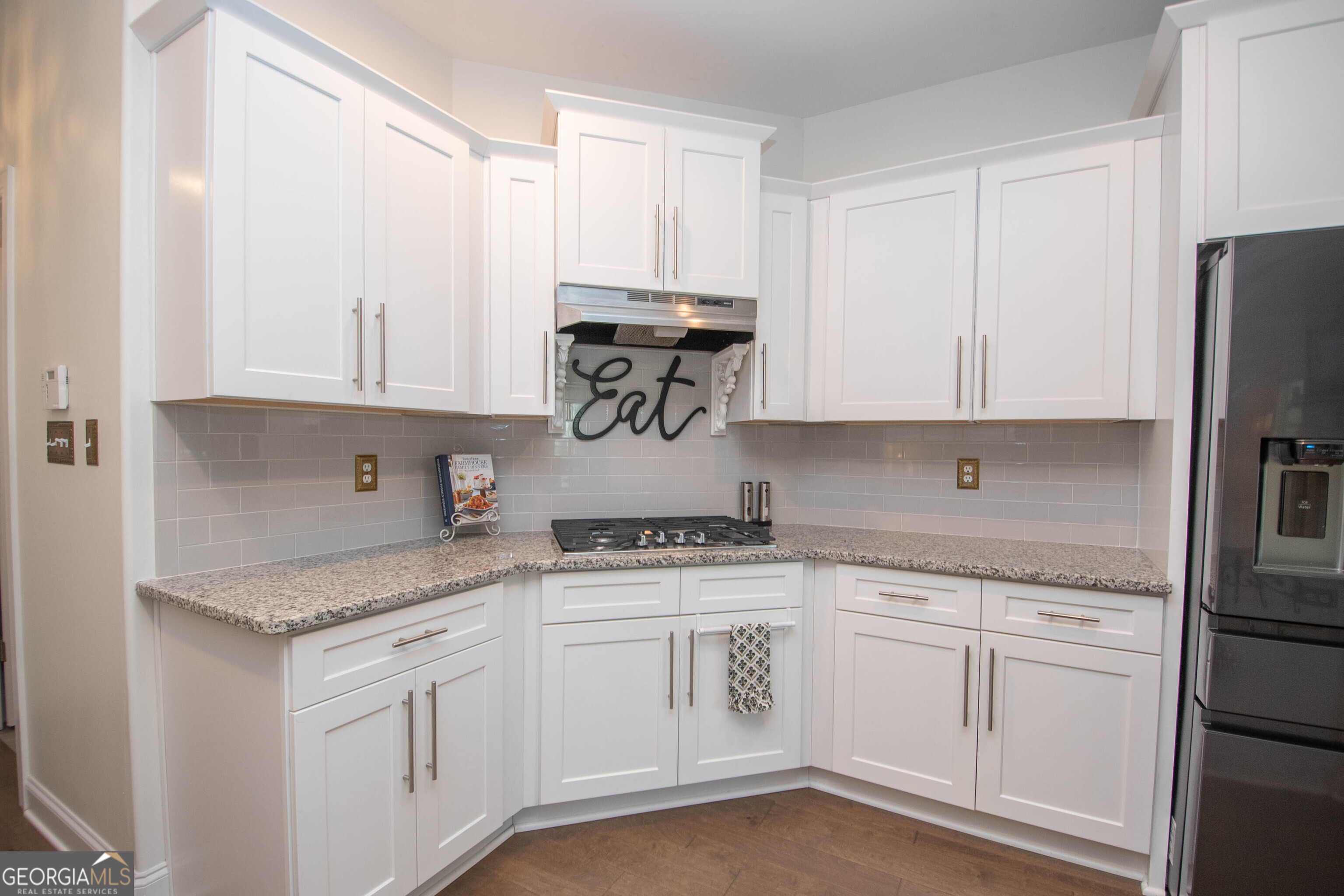 6 Delaware Way Newnan, GA 30265 - Photo 19 of 42 a kitchen with granite countertop white cabinets and white appliances