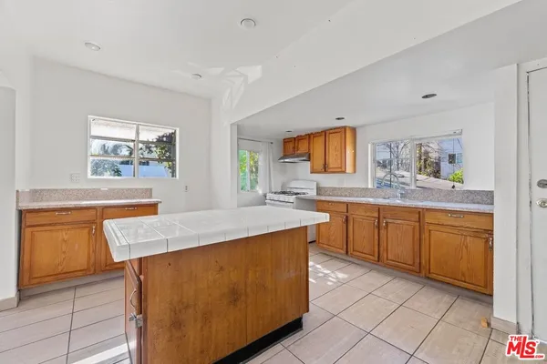 a kitchen with wooden cabinets and center island
